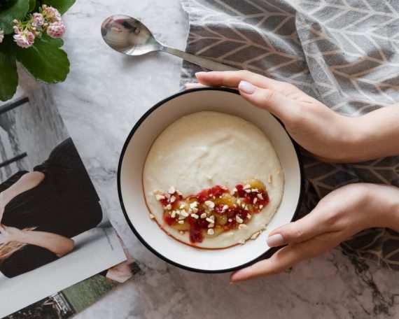 Delicious breakfast bowl with creamy cereals topped with fruit jam and nuts, perfect for a cozy morning.